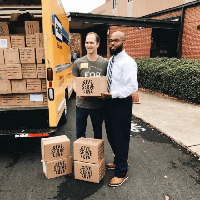 volunteer delivering boxes of food to a local school
