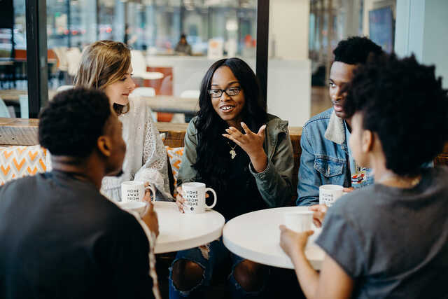 group of young adults having a conversation in a coffee shop