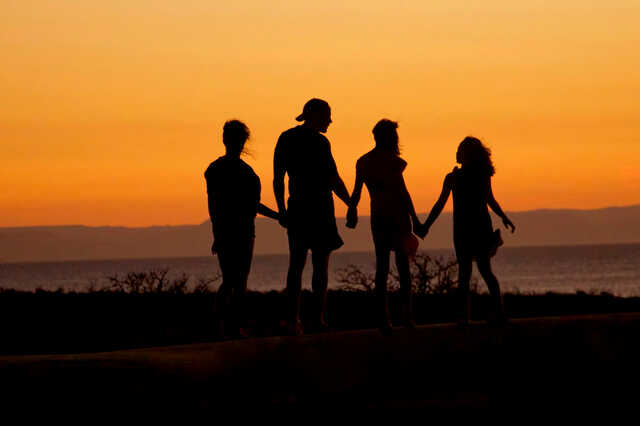 family silhouette by the ocean