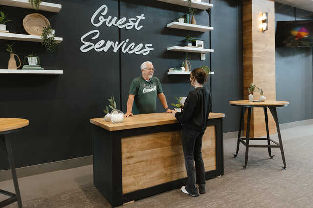volunteer talking to a guest at the guest services desk