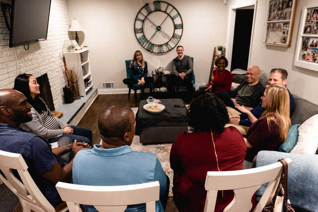married small group sitting together in living room