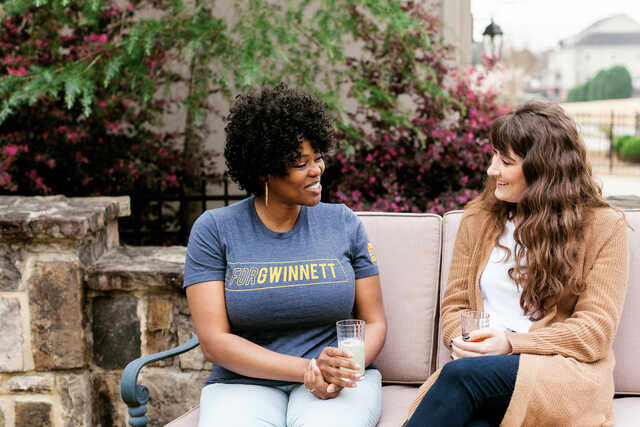 women having a mentoring conversation on an outdoor bench